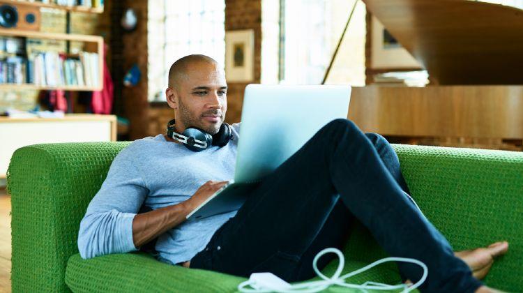 Man Building Cv On Green Couch 1